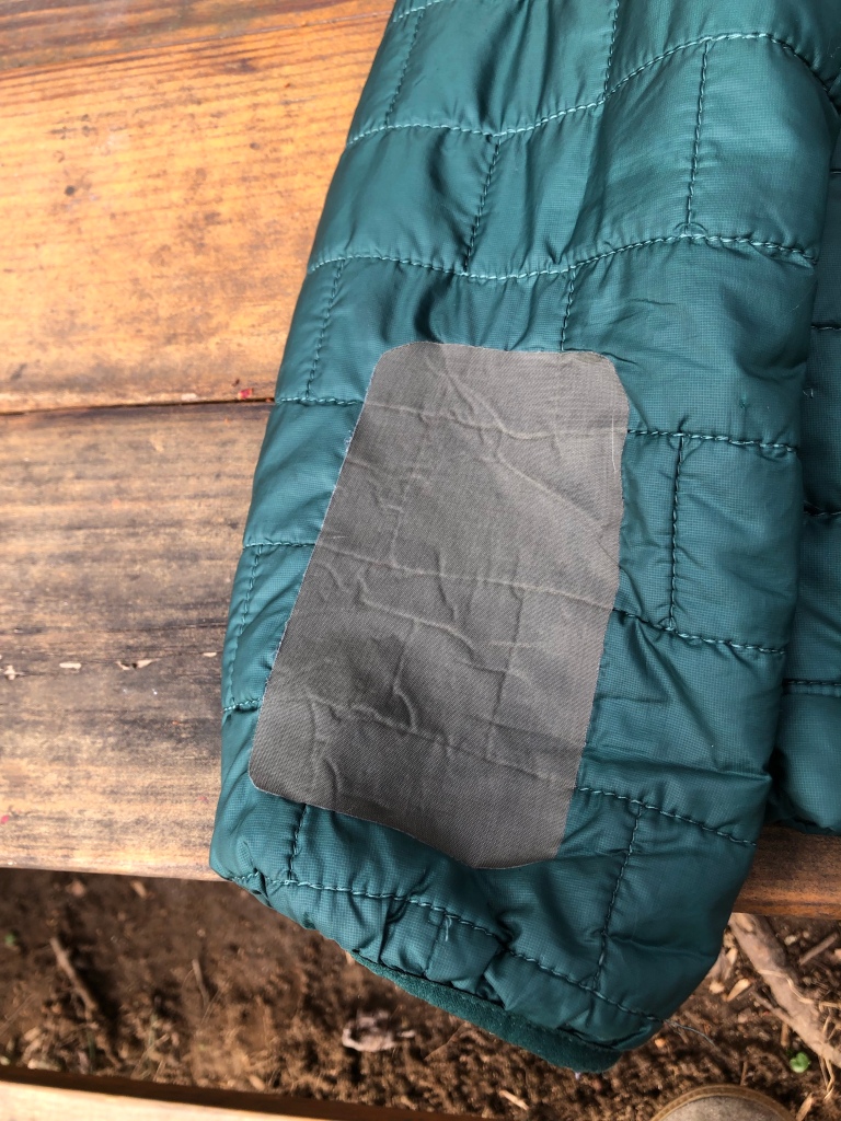 Green Patagonia Nano Puff® jacket patched with olive green GEAR AID Tenacious tape