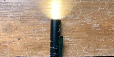 Black Olight i3T EOS flashlight all lit up