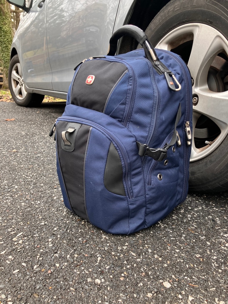 Blue Swiss gear bag next to car wheel